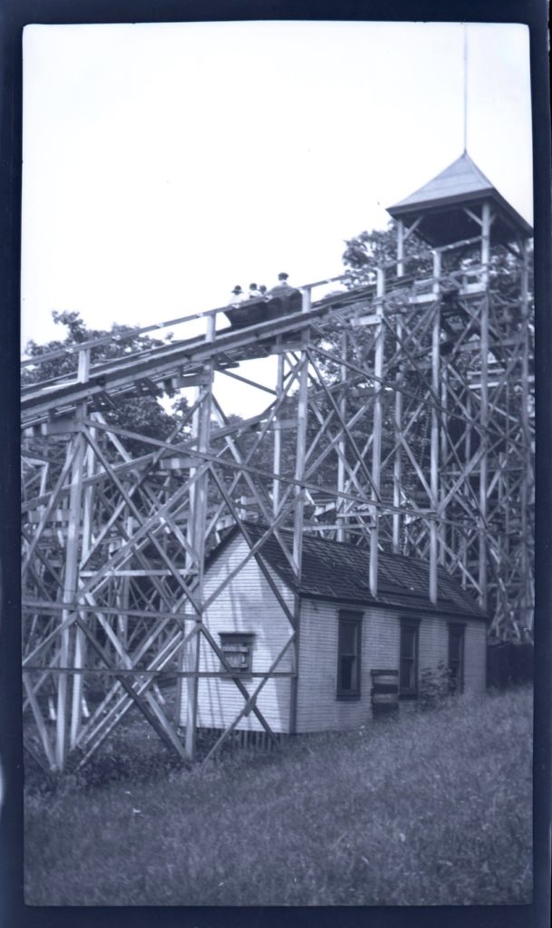 People riding "Figure 8" wooden roller coaster at Oakford Park