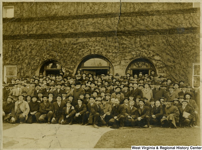 Group portrait of men in front of building