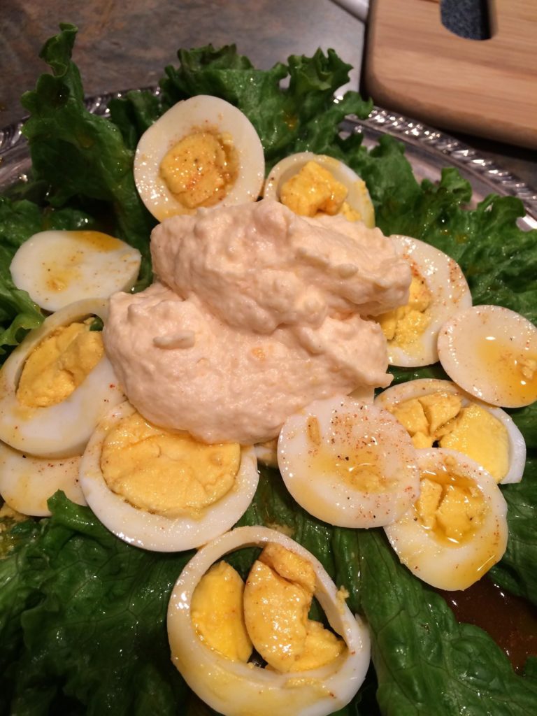 Image of halved eggs, topping, and bed of lettuce