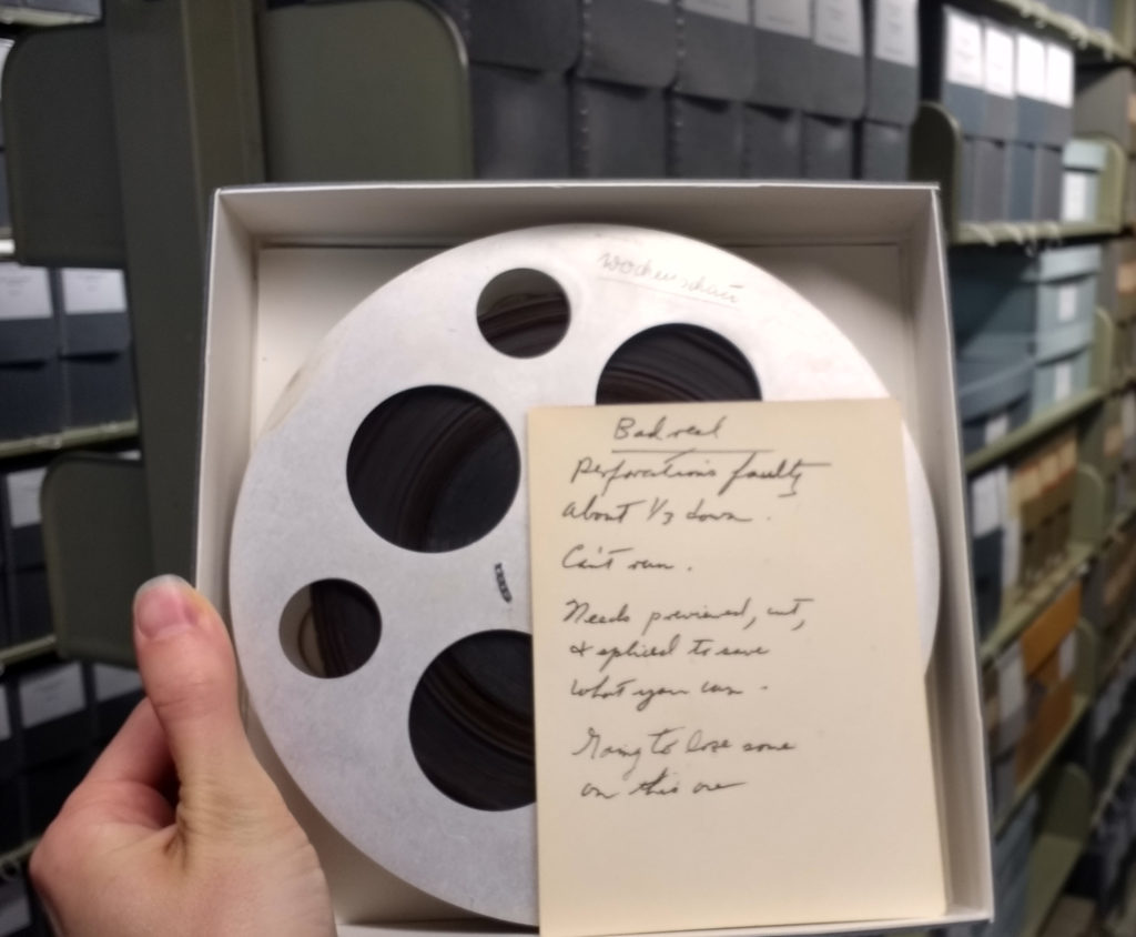 Reel of film with a note beside it