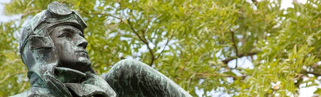 Top of statue showing man in aviator cap/goggles