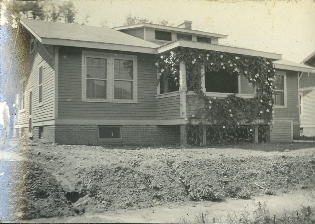 Minter home in Nitro, with flowers on porch and a dirt front yard