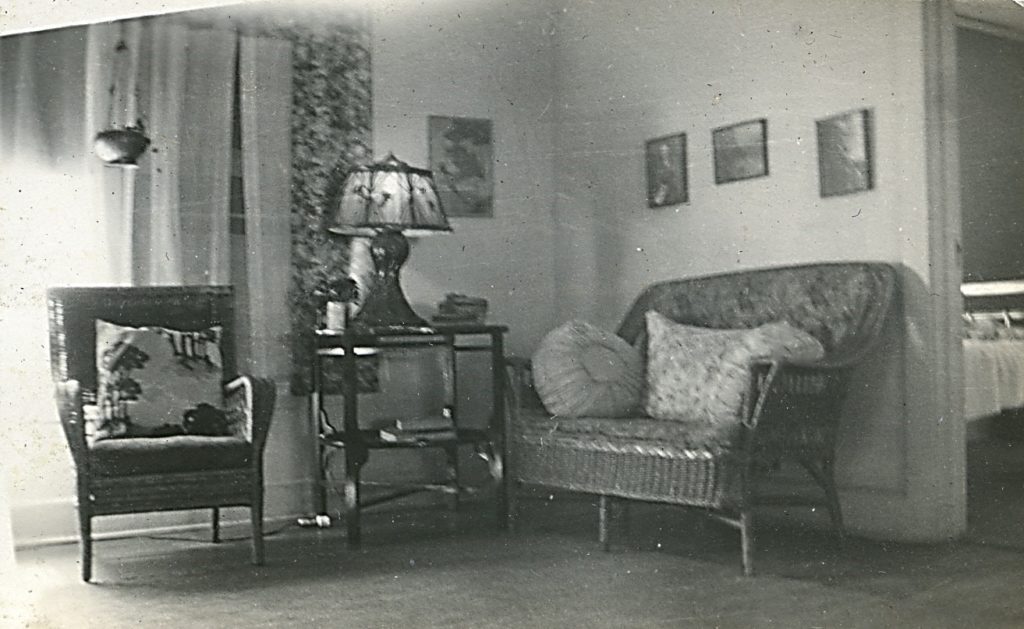 Interior of Minter home in Nitro, showing wicker chair and loveseat