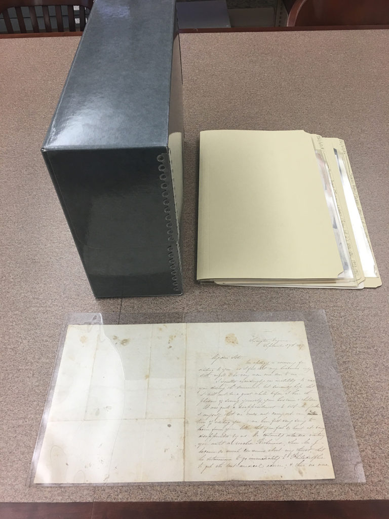 Archival document case, archival folder, and document on table