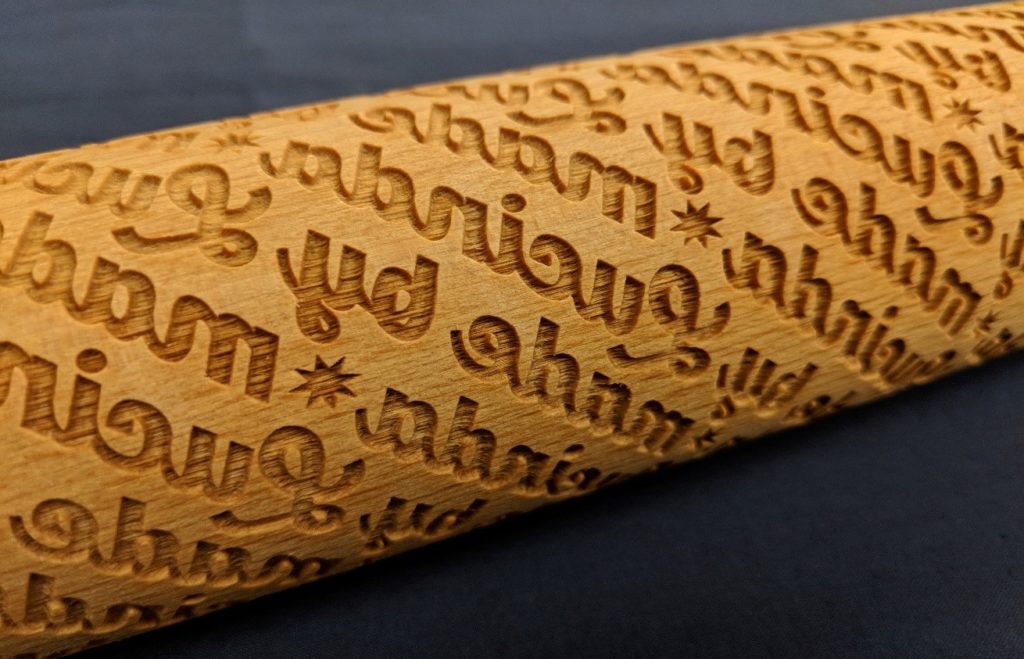 Close up of laser cut rolling pin that says "Made by Lucinda Ebersole"