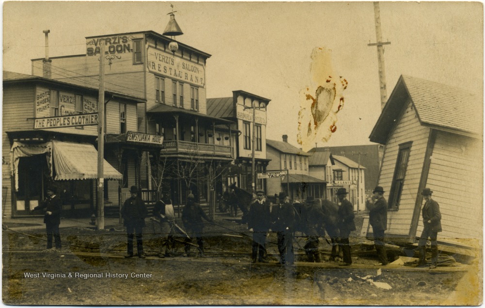 Image showing town buildings and men moving a small building across a street