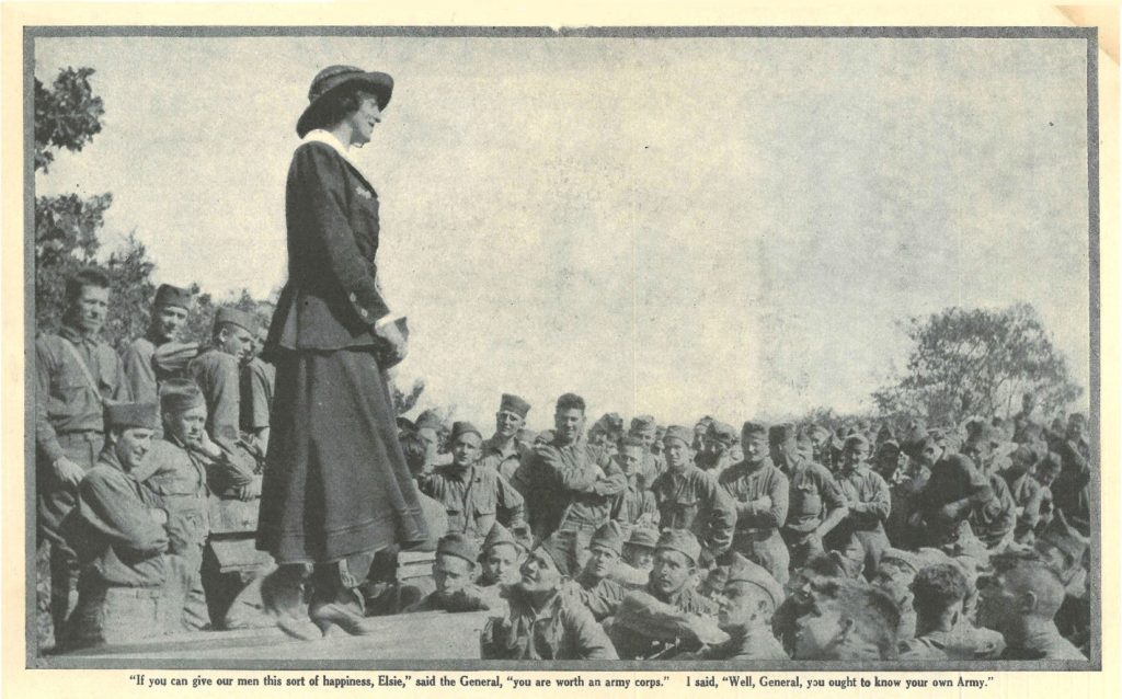 Photo of Elsie Janis standing in front of a group of soldiers