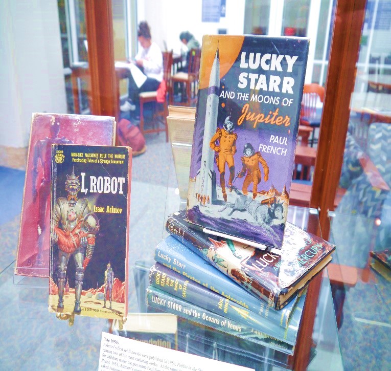 Part of an Isaac Asimov exhibit case, showing off books including Lucky Starr and I, Robot