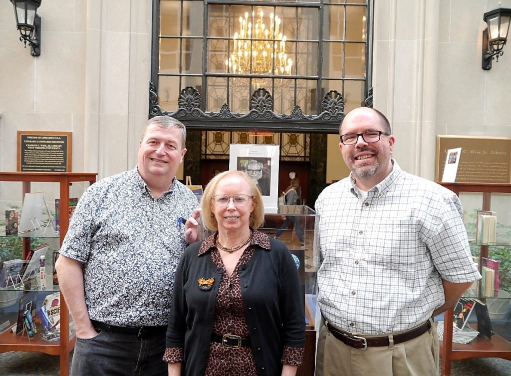 Group photo of Andy Duncan, Stewart Plein, and Dr. Jay Cole in front of the Isaac Asimov exhibit.