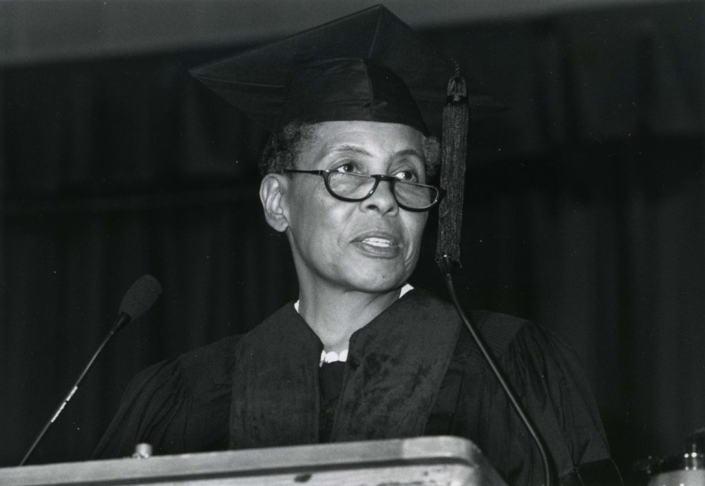 Ancella Bickley wearing a graduation gown and mortarboard hat