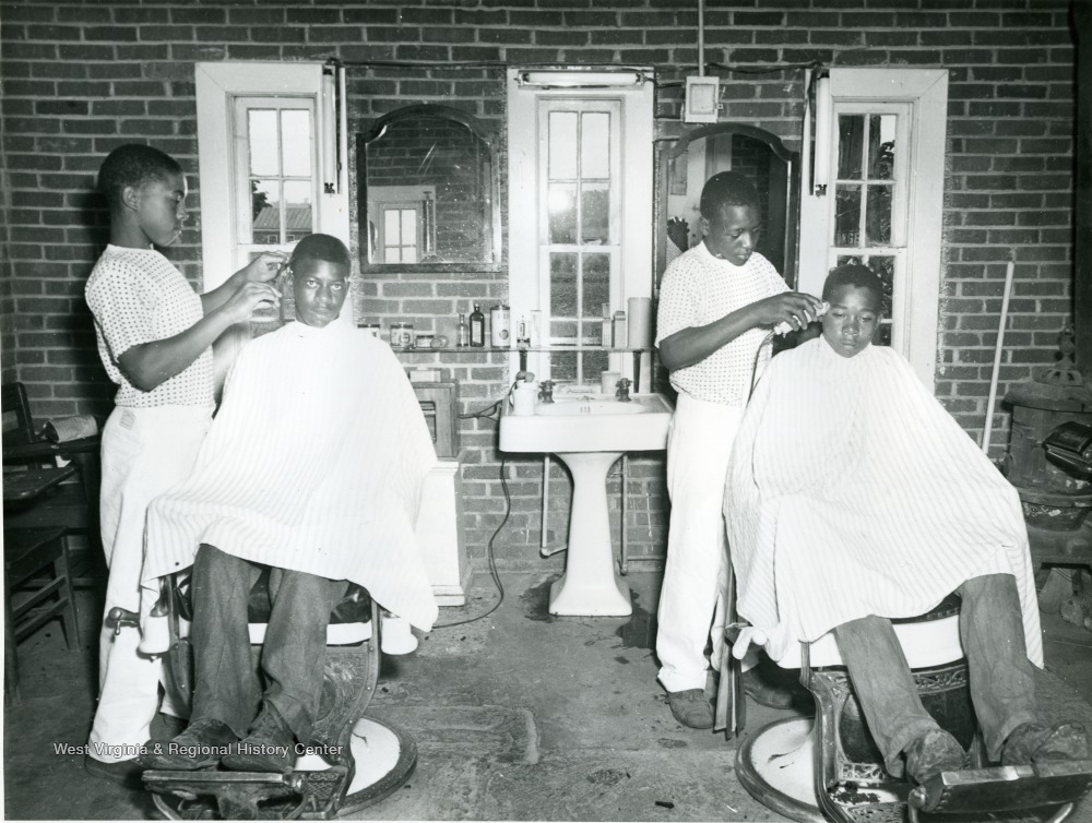 African-american boys giving each other haircuts inside a barbershop