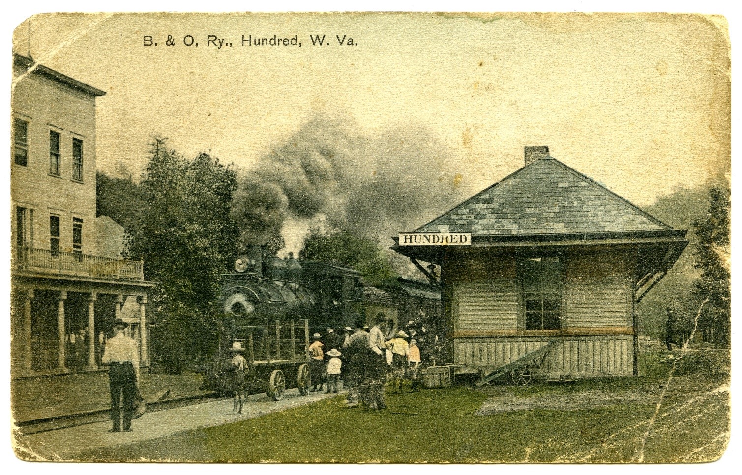 Small train depot, train track with train, and unidentified building