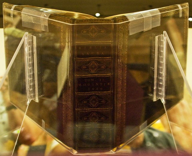 Large old book in a clear plastic book cradle