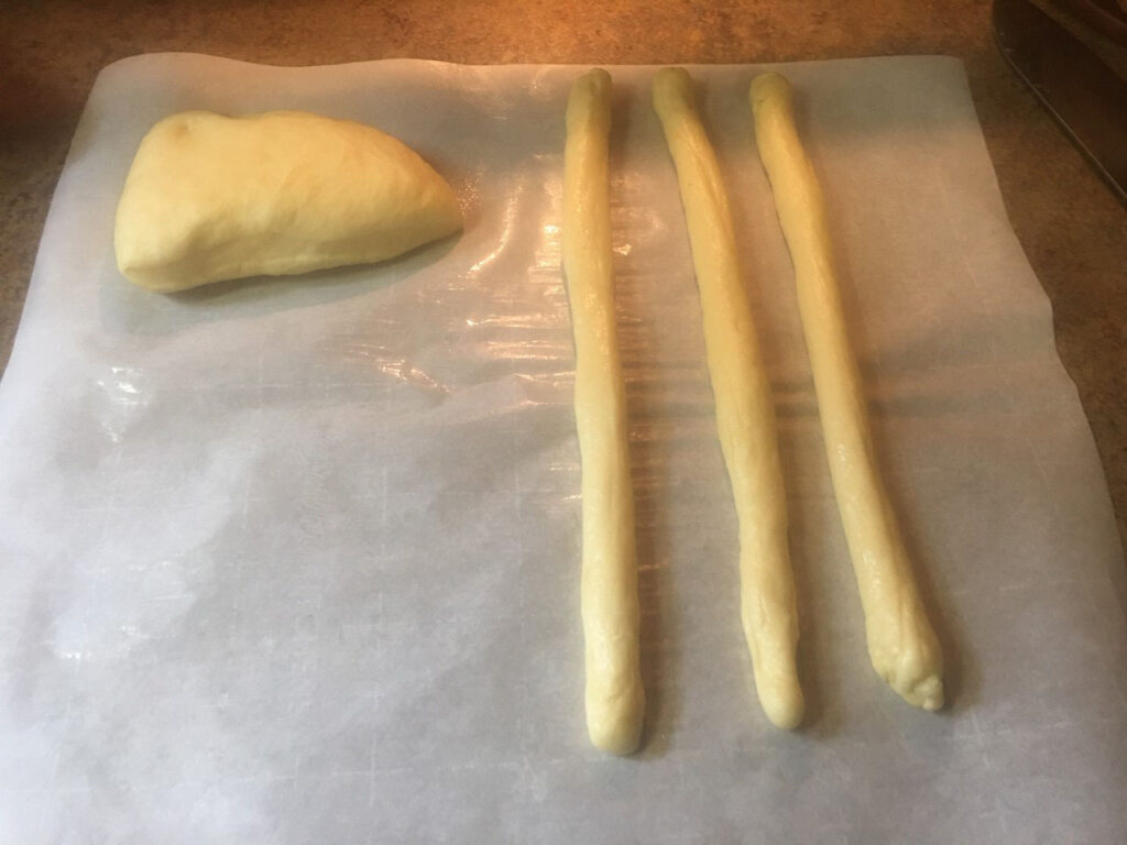 Strips of dough and ball of dough on wax paper.