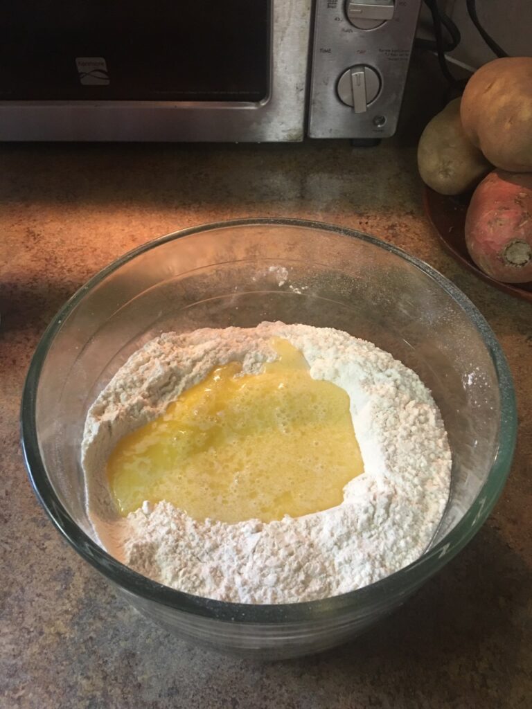 Wet ingredients in center of glass bowl of flour.