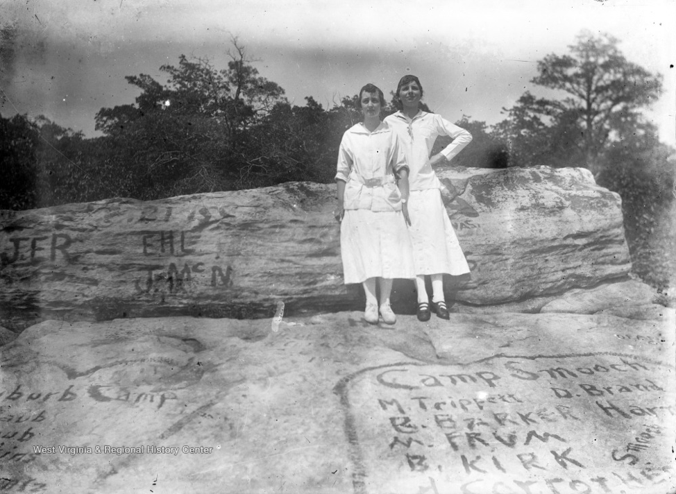 Two Girls on Graffiti Covered Rock