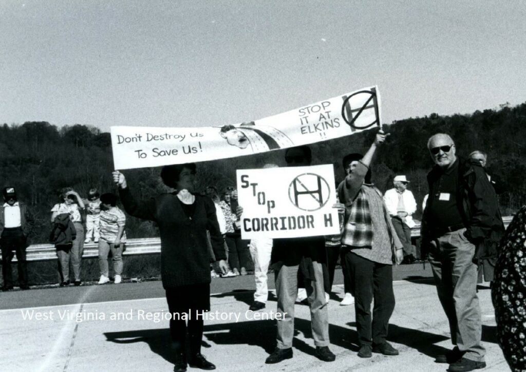 Group holding anti-Corridor H protest signs