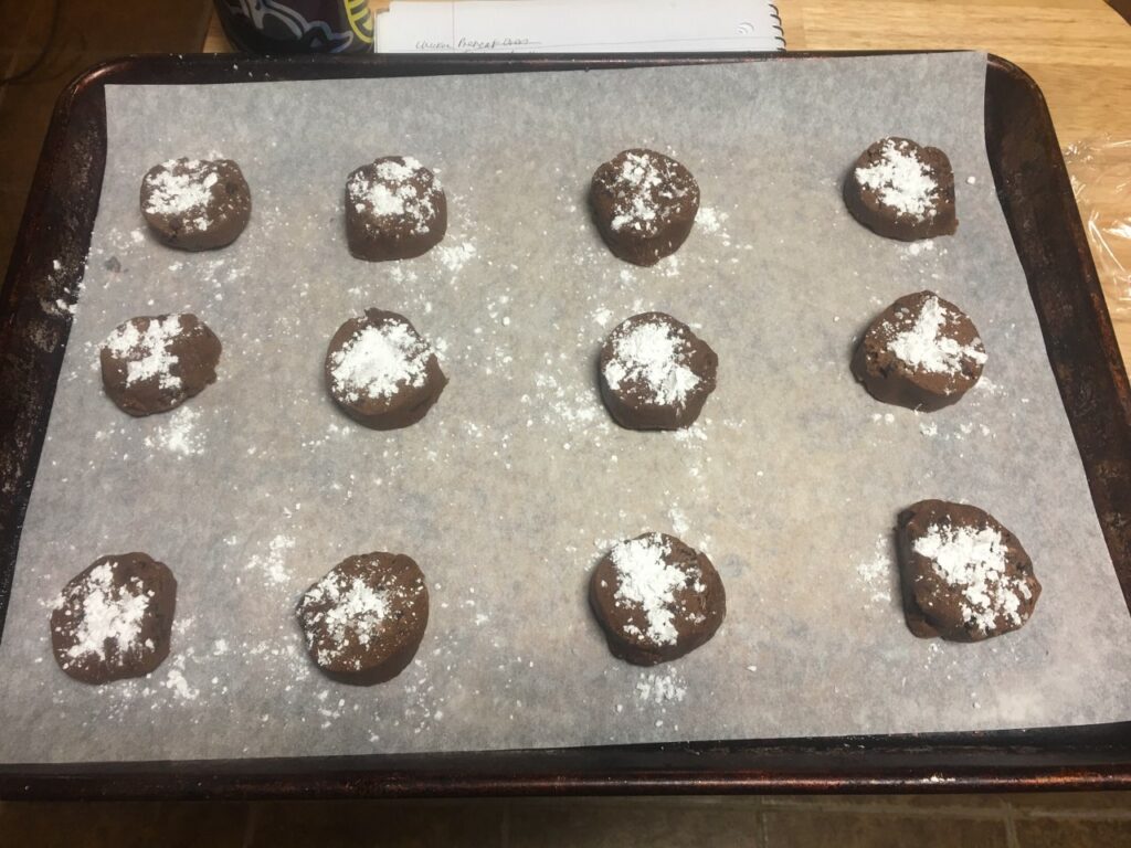 Balls of dough on cookie sheet, dusted with powdered sugar