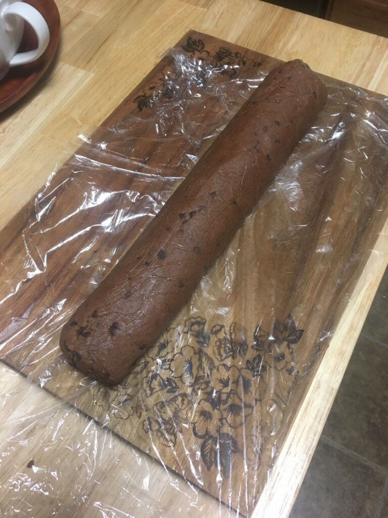 Log of cookie dough on plastic wrap