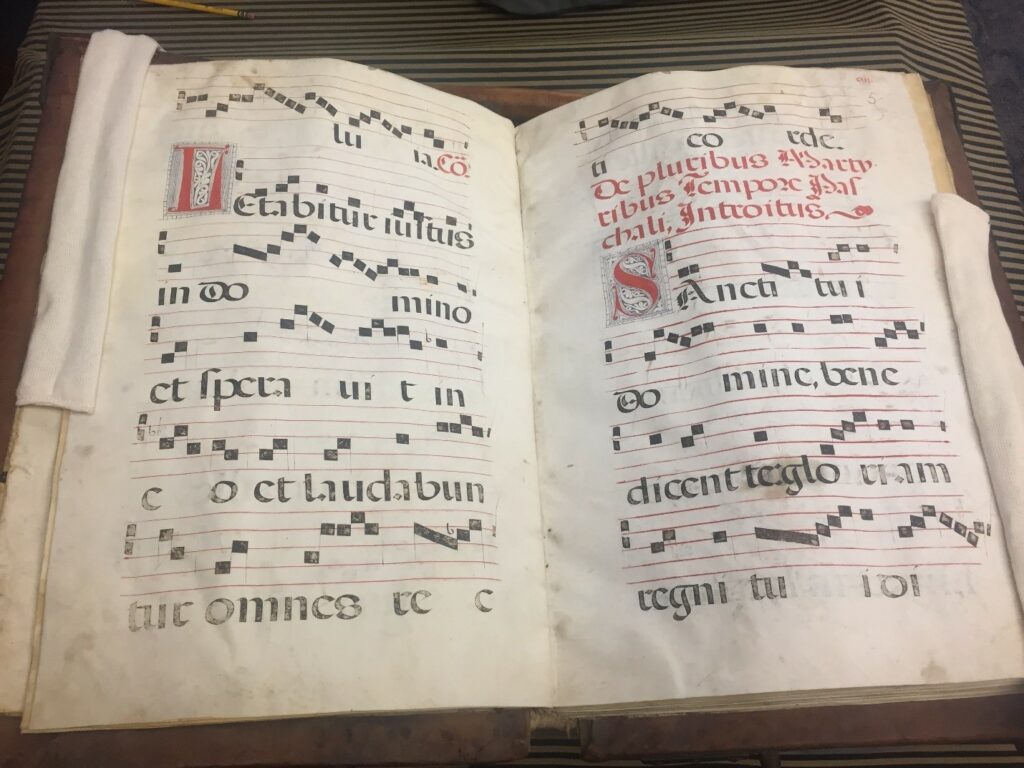 Pages of a book with musical notation and Latin text