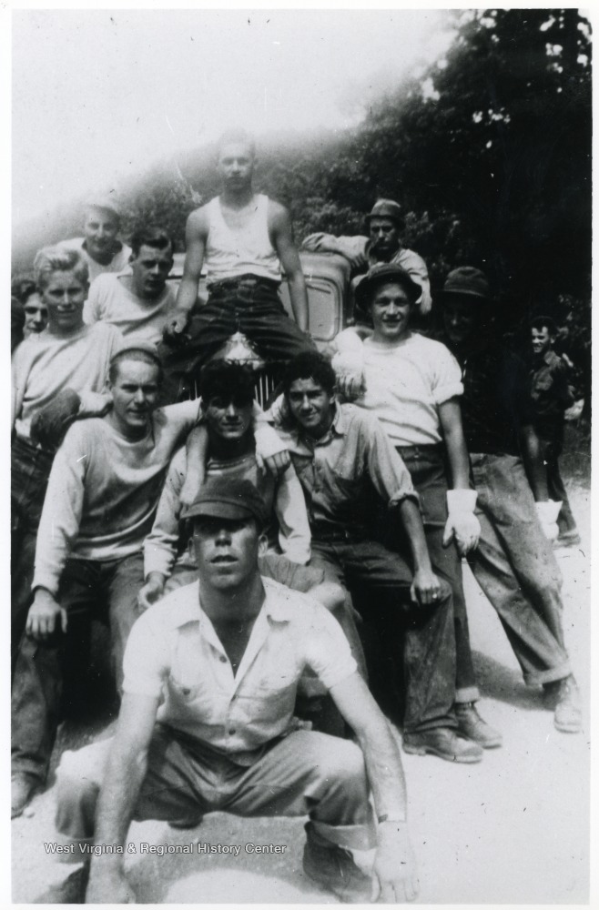 Group of men posed on and around a car